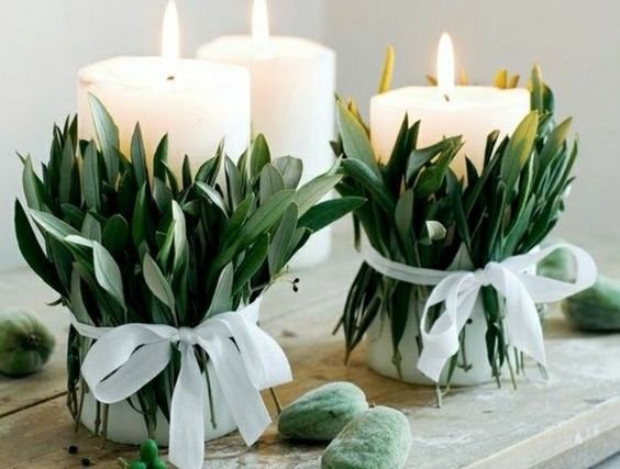 green leaves tied around a candle by a ribbon