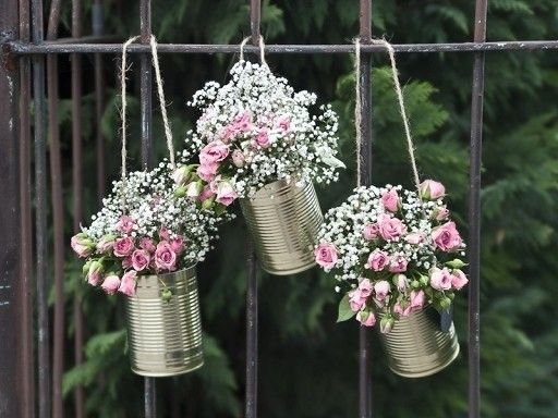 tin cans containing bouquets of flowers