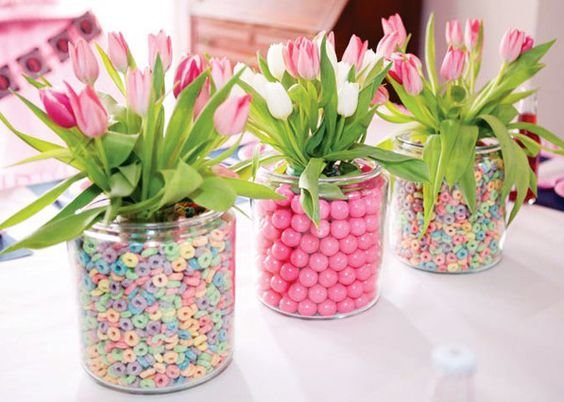 candies and colorful cereals in jars in glasses with flowers