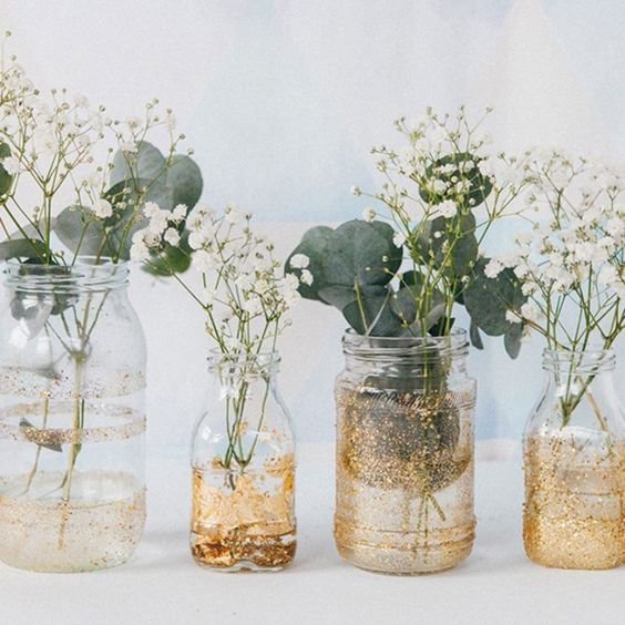 glass jars of different sizes containing flowers