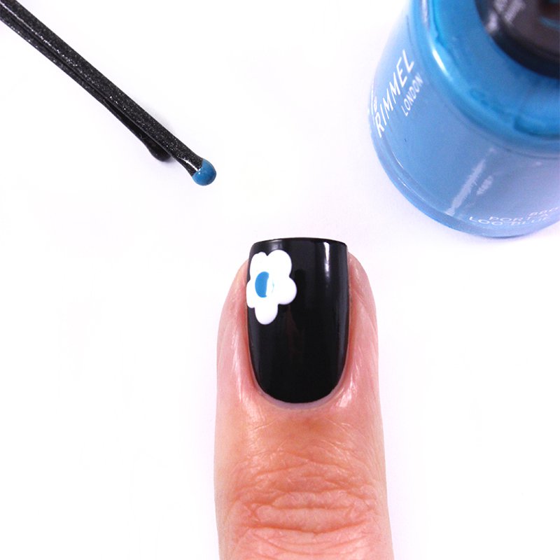 small flower white heart blue on a nail varnish in black