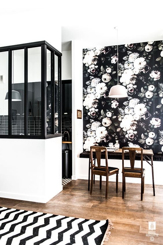 black wallpaper with large white flowers above a table glued to the wall