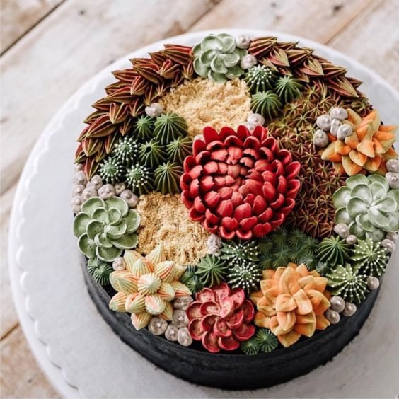 beautiful cake with dozens of succulents in buttercream on it
